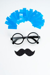 Blue Monday creative concept. The face of a man in glasses, mustache with blue hair on a white...