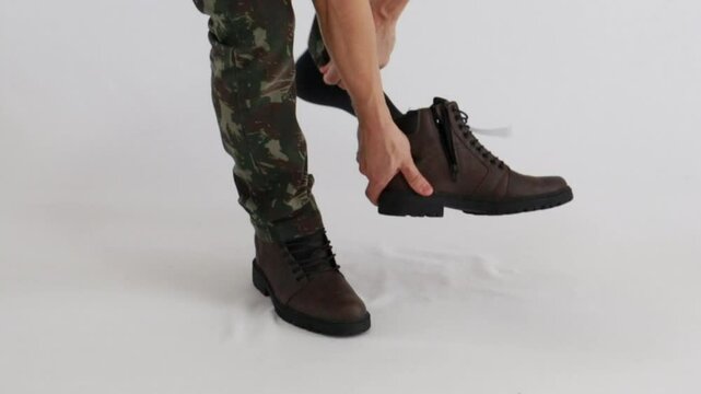 homem colocando botas 