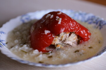 A plate of food featuring a base of rice topped with a red pepper.