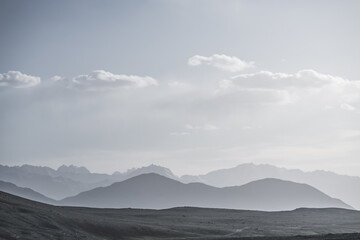 Panoramic minimalist landscape of mountain ranges in Pamir in the Tien Shan Mountains in Tajikistan, silhouette of mountain peaks, landscape for the background