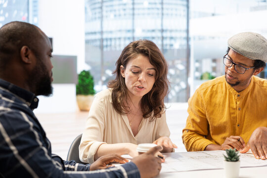 Entrepreneur collaborates with a real estate team to strategize investment opportunity before leasing the property, planning a high class office space relocation with modern designs.