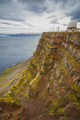 A radar station sits atop the rocky cliffs of Bolafjall mountain in Iceland's Westfjords, near...
