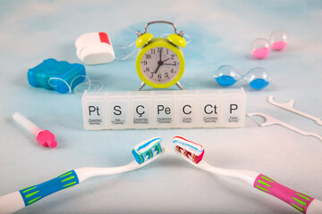 A composition showing daily dental care on a white background. Toothbrushes, clock and weekly chart