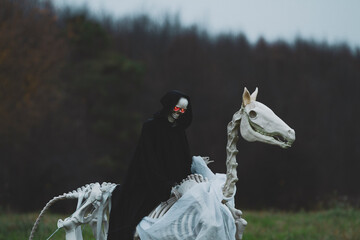 Grim Reaper on a Skeleton Horse  with Glowing Red Eyes: Spooky Halloween Scene.