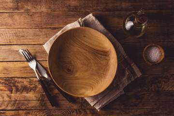 Rustic wooden table setting with empty wooden bowl
