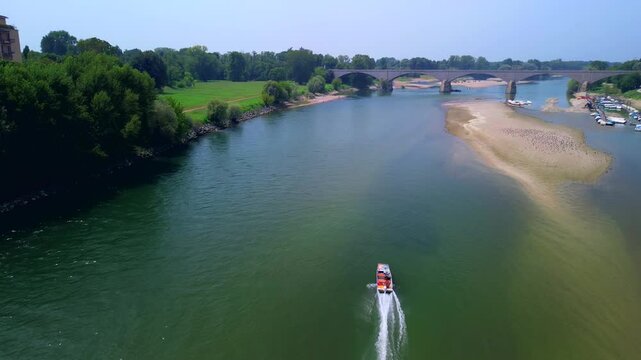Drone view of the Ticino River and the covered bridge Ponte Coperto, which is used by vehicles and pedestrians. Arched structure. Clear transparent water. Motorboat. Italy. Pavia Italy 15.10.2024