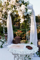 Elegant Outdoor Wedding Ceremony Setup with Floral Arch and Table
