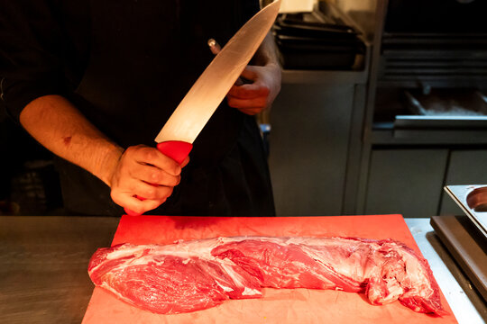 Master chef skillfully preparing meat in a professional kitchen