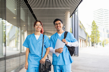 Two smiling nurse students walking outside the university