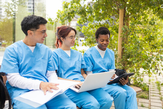 Diverse nursing students studying together outdoors