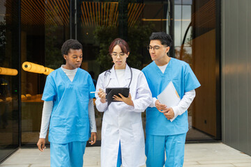 Nursing students discussing with tablet outside university