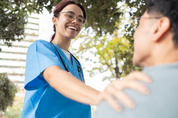 Nurse student caring for elderly patient outdoors