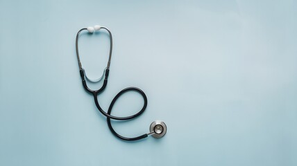 Fototapeta premium Medical stethoscope and forceps on light blue grid background