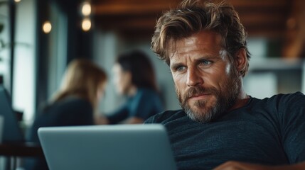 A thoughtful man uses a laptop, surrounded by a quiet and modern workspace, combining focus, relaxation, and the pursuit of knowledge in harmony.