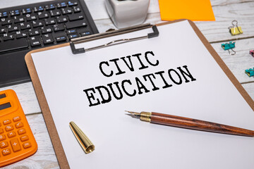 CIVIC EDUCATION On a wooden background, a notepad with text with a cup of coffee and glasses.