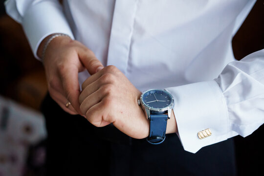Elegant Man Adjusting His Watch in a Classic White Dress Shirt