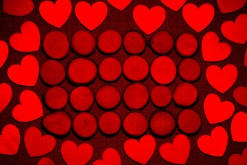 Wooden buttons surrounded by wood love hearts, with the image bathed in red light.