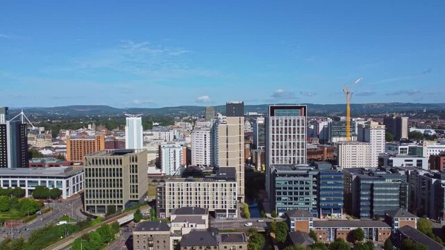 Aerial drone footage of Cardiff city centre as seen from Atlantic Wharf and Butetown neighbourhoods with modern apartment and office blocks in the foreground. Diagonal rise shot.