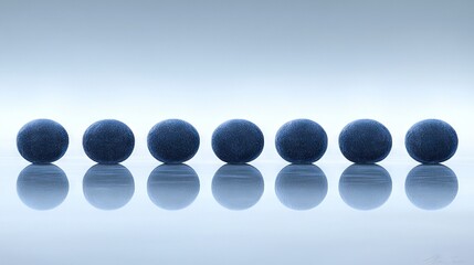   A line of blue spheres resting alongside one another on a mirrored surface against a white backdrop
