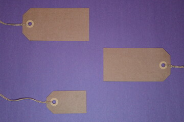 Blank brown paper tags against a purple background