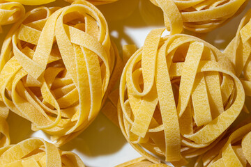 Uncooked Egg-Based Fettuccine Pasta: A Culinary Canvas of Ribbon-Shaped Macaroni, Creating a Lively...
