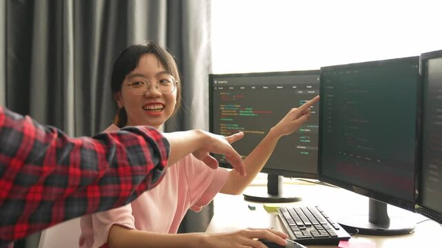 Slow motion back end software developer engineer for computer programming working together on debugging writing computing code, solving complex algorithms display on monitor in office. Burgeoning