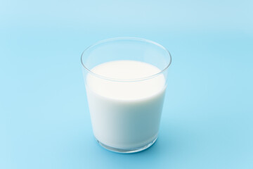 水色背景にグラスに入った牛乳
