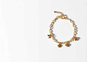 Gold lucky charm bracelet with four-leaf clover and rainbow charms
