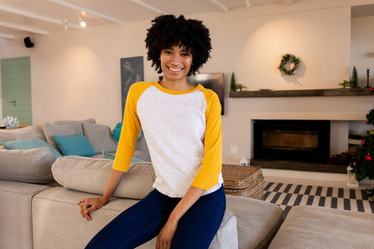 Smiling woman relaxing on couch in festive living room, at home