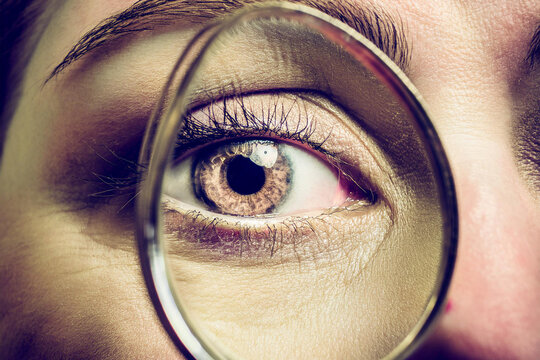 Beautiful detailed macro photography of the eye of a man, woman and children through a magnifying glass as a close or careful focus on the health and optics of vision
