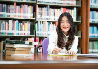 Interesting Asian students in the library, searching for knowledge, studying, doing homework, knowledge and information seeking concept.