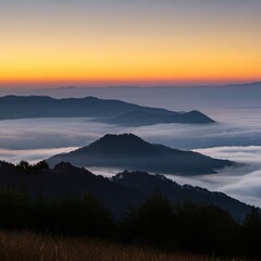Obraz premium Serene sunrise over a misty mountain range