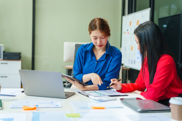 Obraz premium Two young female business consultants work on startup, collaborating on mobile app development social media strategies. whiteboards, documents, they aim to build a successful e-commerce business.