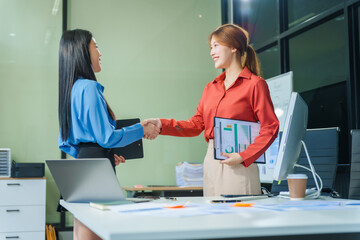 Obraz premium Two young female business consultants work on startup, collaborating on mobile app development social media strategies. whiteboards, documents, they aim to build a successful e-commerce business.