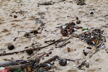 On the sand or the edge of the beach which is full of various kinds of rubbish. environmental and recycling concept