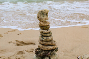 Coral rocks are stacked on the beach with a sea background