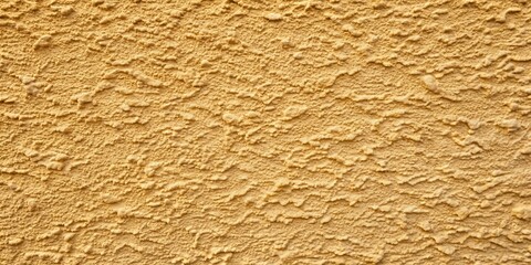 A close-up view of a textured wall with a warm, ochre hue, featuring a rough, uneven surface with subtle variations in color and depth.
