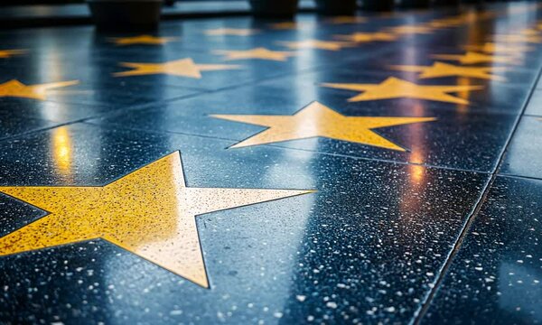 A close-up view of yellow stars on a dark floor, likely part of a famous walkway.
