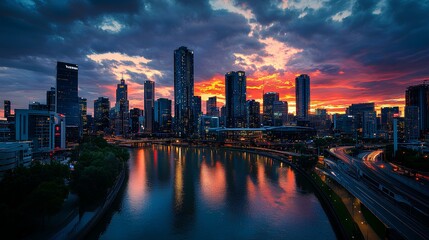 Fototapeta premium A stunning sunset over a city skyline, reflecting vibrant colors on the water, showcasing modern architecture and a dynamic urban landscape.