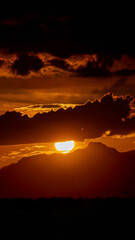 Sunset behind dark clouds, creating a dramatic and moody evening sky scene.