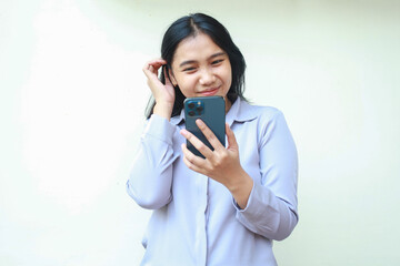 elegant asian young business woman show femininity using smartphone to video call, read good news and social media online shopping, wearing formal shirt standing over white background, looking screen