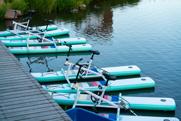A row of catamarans at the pier on the river.