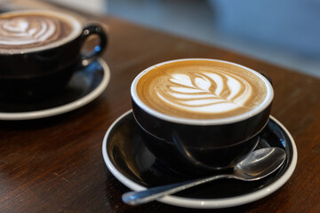 Two mugs of coffee. Latte art. Sit-in cafe  dining or restaurant casual style and lifestyle. Enjoy the morning with a coffee. Many coffee choices, such as cappuccino, latte, flat white, long black.