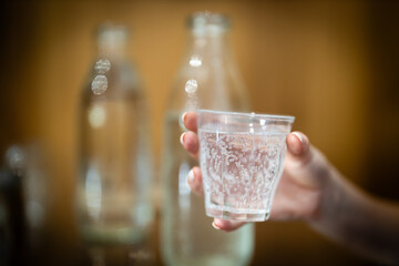 Holding a fresh glass of fizzy mineral soda carbonated filtered water at a cafe or restaurant....