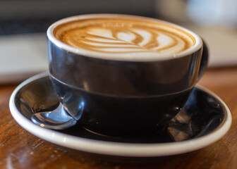 Mug of coffee. Latte art. Sit-in cafe dining or restaurant casual style and lifestyle. Enjoy the morning with a coffee. Many coffee choices, such as cappuccino, latte, flat white, long black.