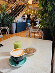 WASHINGTON - September 10, 2024: Matcha latte, coffee latte, and chocolate chip cookie at ambient Little Oddfellows cafe in Seattle