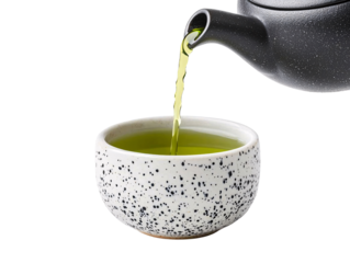 Steaming green tea poured from a black teapot into a spotty white cup capturing the essence of relaxation and culture
