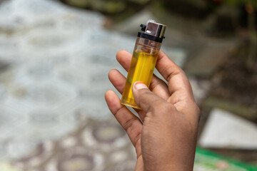 Female hand holding a plastic gas lighter.