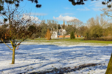 Winter scene in a park in the UK, a frosty snowy start with blue skies.
