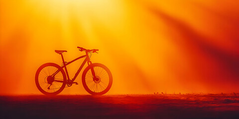 Obraz premium Silhouette of a Mountain Bike Standing Against a Fiery Orange Sunset Sky